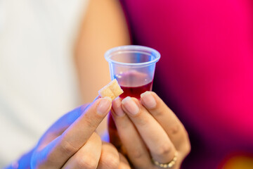 Mujer tomando la comunión - pan y vino. Concepto de fe y práctica cristiana