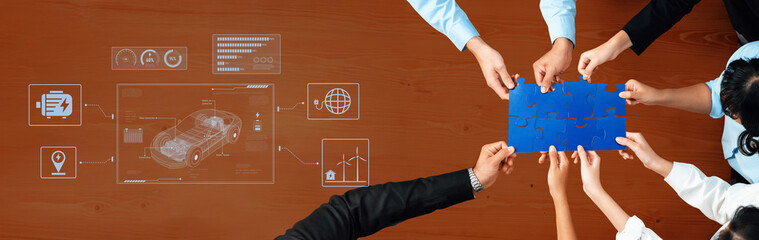 Hands of diverse team members work together on a blue puzzle piece while digital graphics illustrate innovation and strategy in a modern office setting. Trope