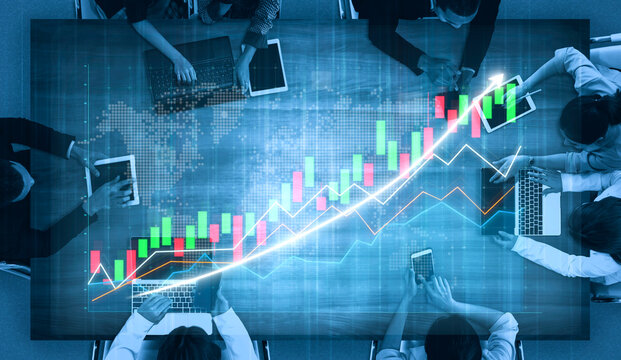 A diverse business team collaborates in a modern office, analyzing financial data and charts on laptops and tablets. The scene reflects teamwork and strategic planning. Impute