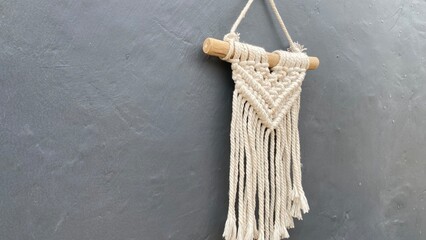 Macrame wall decoration made from knitted white wool thread with an angle from the side and hung on...