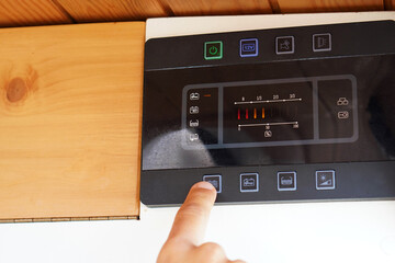 Fototapeta premium A man checking the battery charge level of his solar-powered camper van.