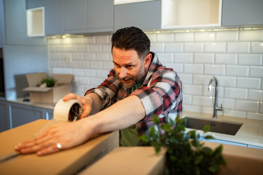 Man packing boxes in kitchen