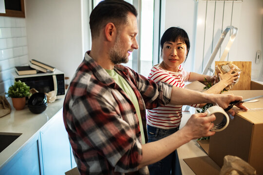 Young couple packing boxes in kitchen