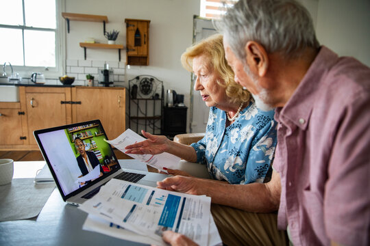 Senior couple video calling with their financial counselor at home