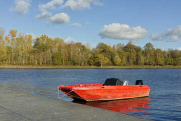 Fototapeta premium Red launch boat on the lake, that coaches use for rowing team.