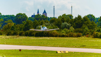Beautiful summer landscape view with a landing sports airplane and buildings at airport Straubing, Bavaria, Germany