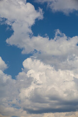 Cumulus clouds in the blue sky. Heavenly vertical background