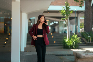 Asian businesswoman walking while talking on cellphone