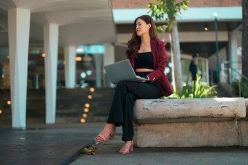 Asian executive woman working on laptop outdoors
