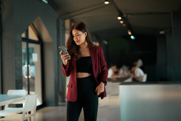 Asian businesswoman browsing smartphone connecting from modern office or cafe