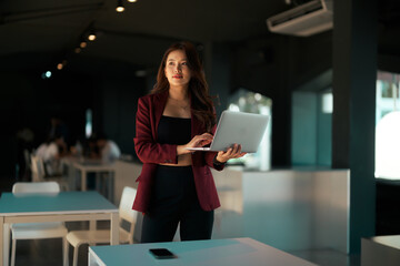 Asian businesswoman working on laptop in modern office