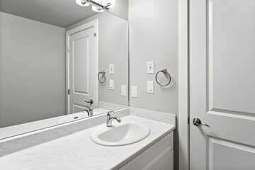 Bathroom with a white sink and a white door