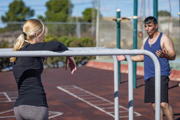 Naklejka premium young couple doing calisthenics exercises in an outdoor park