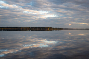 wonderful sunset by the lake, autumn landscape, the sky is reflected in the calm surface of the lake, beautiful reflections in the water, Burtnieki Lake, Latvia