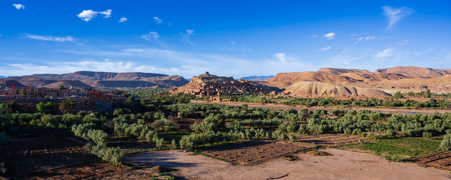 Scenic view of a desert landscape with greenery under a clear blue sky. Ait Benhaddou. Morocco