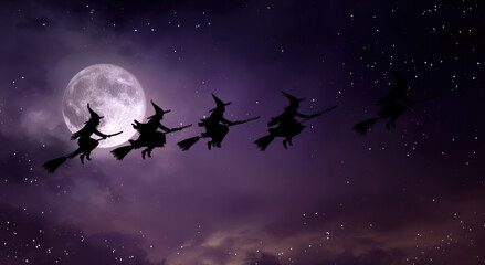 Silhouettes of witches flying on broomsticks across a starry night sky with a large full moon illuminating the scene, creating a mystical and enchanting atmosphere