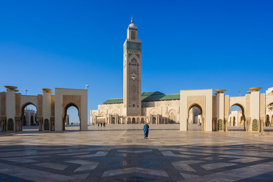 Courtyard of a grand mosque with intricate architecture under a clear blue sky. Casablanca, Morocco