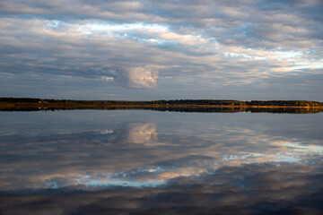 wonderful sunset by the lake, autumn landscape, the sky is reflected in the calm surface of the lake, beautiful reflections in the water, Burtnieki Lake, Latvia