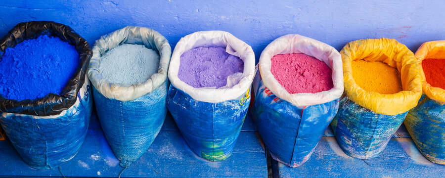 Colorful sacks of vibrant pigments against a blue painted wall. Chefchaouen, Morocco