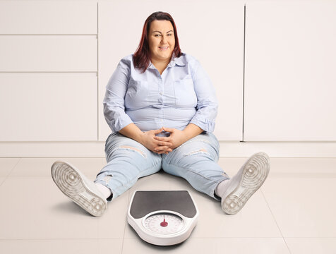 Lazy overweight woman sitting on the floor