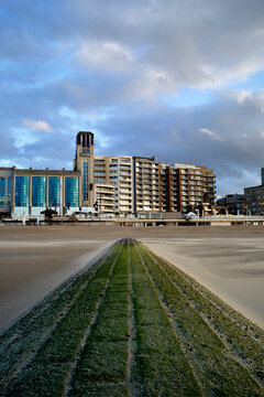 Distant view of urban beachfront with modern buildings under a cloudy sky. Blankenberge, West Flanders, Belgium
