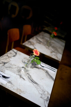 Elegant marble tables with roses in a cozy dimly lit restaurant setting. Blankenberge, West Flanders, Belgium