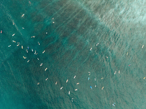 Aerial view of surfers waiting for waves on the ocean's surface. Lombok, Tanjung Ann, Indonesia