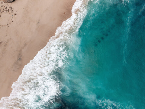 Aerial view of beach with sea waves meeting sandy shore. Lombok, Sekaroh, Indonesia