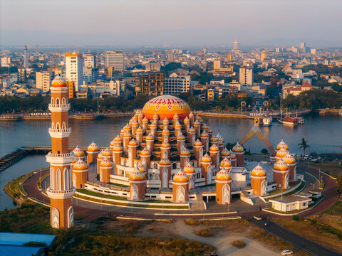 Aerial view of a beautifully designed mosque with many domes set against a city skyline. 99 Domes Mosque, Makassar, South Sulawesi, Indonesia