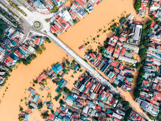 Aerial view of a flooded urban area with muddy river and colorful rooftops. Cao Bang city, Cao Bang, Vietnam