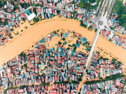 Aerial view of a flooded urban area with colorful rooftops and streets submerged. Cao Bang city, Cao Bang, Vietnam