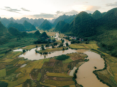 Aerial view of a lush, green landscape with winding river and mountains at sunset.  Phong Nam, Tr˘ng Kh&middot;nh District, Cao Bang, Vietnam