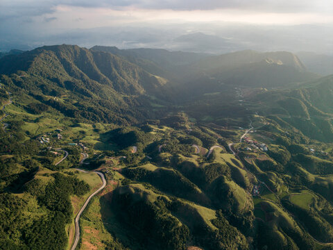 Aerial view of lush green mountains and winding roads under a partly cloudy sky. Loc B&Iuml;nh District, Lang Son, Vietnam 