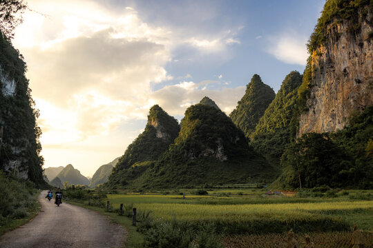 Scenic valley with lush green mountains and a winding road at sunset. Phong Nam, Tr˘ng Kh&middot;nh District, Cao Bang, Vietnam