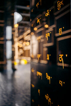 Yellow script on a reflective black wall in a modern, softly lit interior space. Black Virgin Mountain, Tay Ninh, Vietnam
