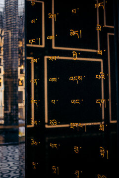 Golden script adorns a reflective black surface with geometric patterns. Black Virgin Mountain, Tay Ninh, Vietnam