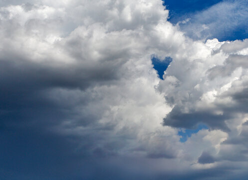 Fluffy white and gray clouds against a bright blue sky.