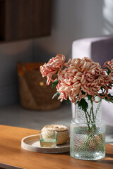 Beautiful pink chrysanthemum flowers in vase on wooden table indoors
