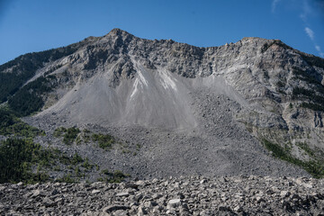 Majestic rocky mountain peak with rugged terrain under a clear blue sky. Waterton Lakes National Park, Alberta, Canada