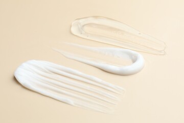Samples of different cosmetic products on beige background, closeup
