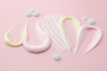 Samples of different cosmetic products on pink background, closeup