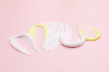 Samples of different cosmetic products on pink background, closeup