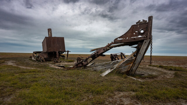 Rusty shipwreck on desolate grassy landscape under a cloudy sky. Hudson Bay, Churchill, Manitoba, Canada