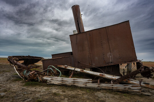 Rusty, abandoned machinery on barren land under a cloudy sky. Hudson Bay, Churchill, Manitoba, Canada