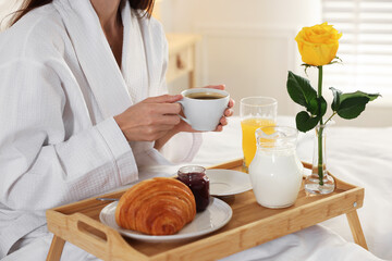 Woman having delicious breakfast in bed, closeup. Hotel room service