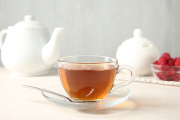 Delicious tea and raspberries served on white table