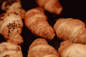 Delicious traditional croissants on the cafe counter on black background