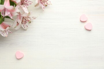 Decorative hearts and flowers on white wooden table, flat lay. Space for text