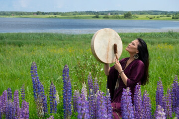 Female shaman drumming among the flowers