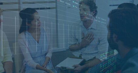 Speaking man in light blue shirt holding clipboard and papers in conference room, with data overlay